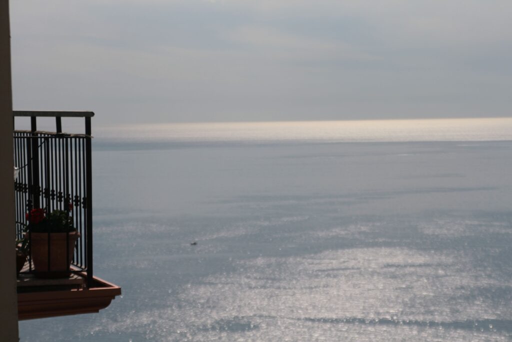 Balcone affacciato sul mare con luce che attraversa l’orizzonte